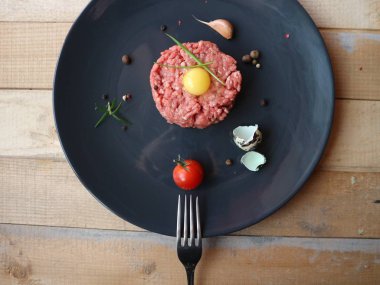 Bıldırcın yumurta, taze soğan, baharat, kiraz domates, sarımsak kıyma. Beyaz ahşap arka plan. Ham maddeler yemek pişirmek için hazır. Portre. Metin için yer. Lezzetli tartar.