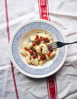 İtalyan geleneksel gnocchi. Kuru domates, Parmesan peyniri, erimiş sarımsak ile geleneksel İtalyan gnocchi otlar ile tereyağı. 