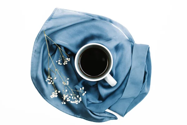 White mug on blue cloth and flowers — Stock Image White mug on blue cloth and flowers Stock Picture