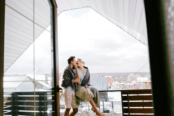 Evde güzel çift birlikte. Güzel kadın ve şık rahat kıyafetler giymiş çekici bir adam ve bir Balkonda duran ve sarılma paket