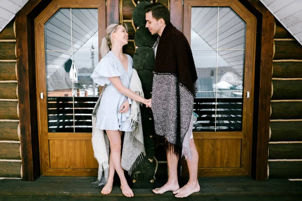 Evde güzel çift birlikte. Güzel kadın ve çekici adam şık rahat kıyafetler giymiş ve paket bir Balkonda duran ve gülüyor.