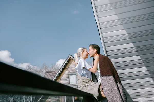 Evde güzel çift birlikte. Güzel kadın ve şık rahat kıyafetler giymiş çekici bir adam ve bir Balkonda duran ve sarılma paket