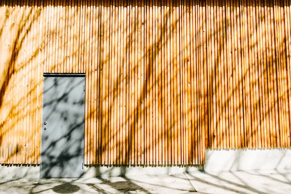 Sombra Árboles Pared Madera Naranja Con Una Puerta Gris Concepto — Foto de Stock