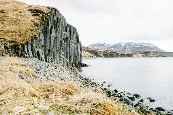 Basalto Acantilado Rocoso Campo Heno Islandia Con Montañas Nevadas Fondo —  Fotos de Stock
