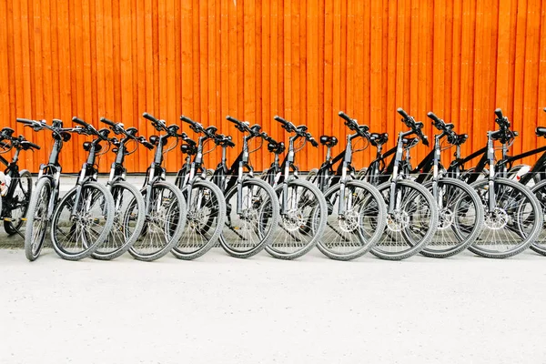 Aluguer Bicicletas Estacionadas Fila Parede Fundo Laranja Imagens De Bancos De Imagens