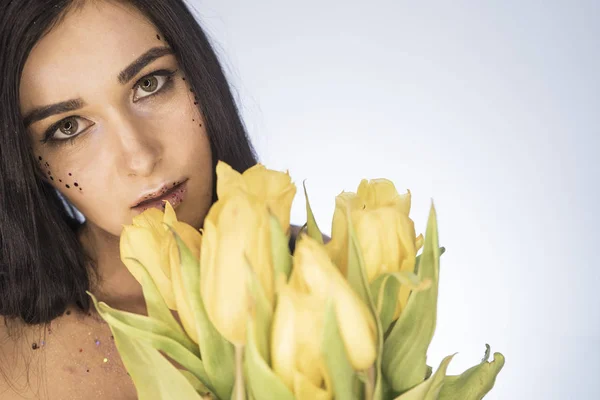 Hermosa chica. Retrato de una chica con tulipanes amarillos . — Foto de Stock