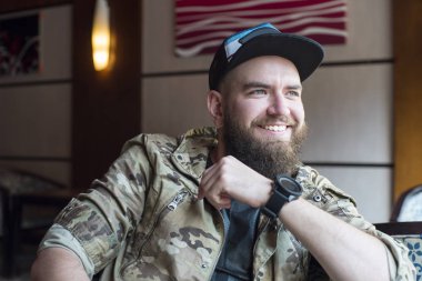 Sakallı bir adam. Sakallı bir gülümseyen adam.