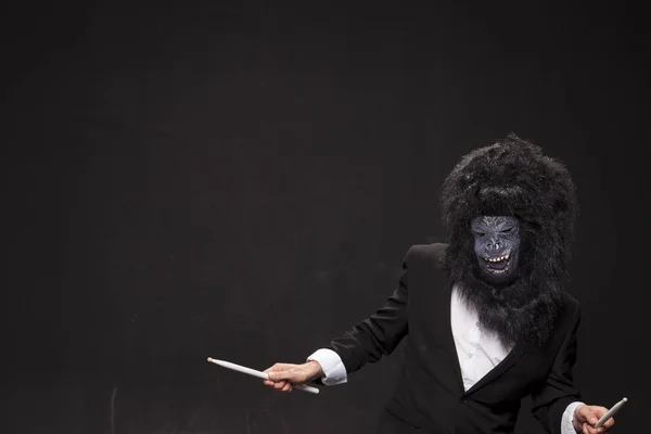 Человек в обезьяньей маске на черном фоне — стоковое фото