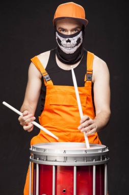 Siyah bir zemin üzerine kızgın davulcu. Bir sakallı