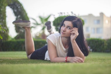 Güzel kız. Esmer çimlere dinleniyor