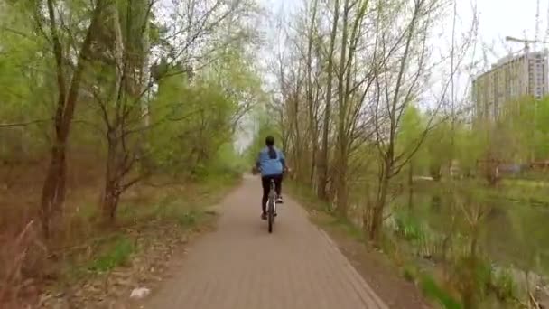 Menina está montando uma bicicleta em um câmera lenta — Vídeo de Stock