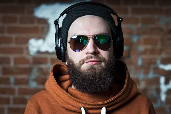 Ein bärtiger Kerl hört Musik. der Typ mit Brille und Kopfhörer — Stockfoto