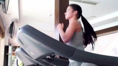 Kız koşu bandı üzerinde çalışan. Spor salonunda güzel kız