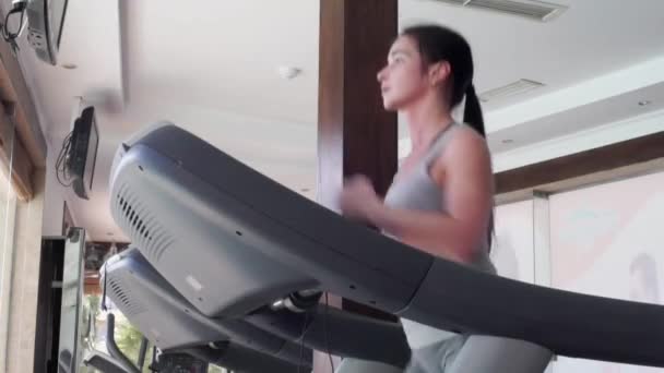 The girl is running on the treadmill. Beautiful girl in sports hall — Stock Video