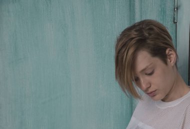 Kız mavi bir arka plan üzerinde. Kısa saçlı güzel kız. Portr