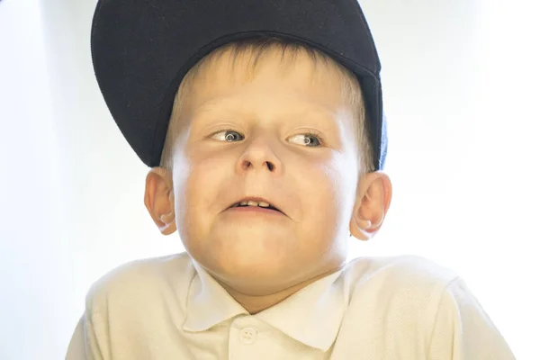 Portrait d'un petit garçon coiffé d'une casquette et chemise blanche . — Photo