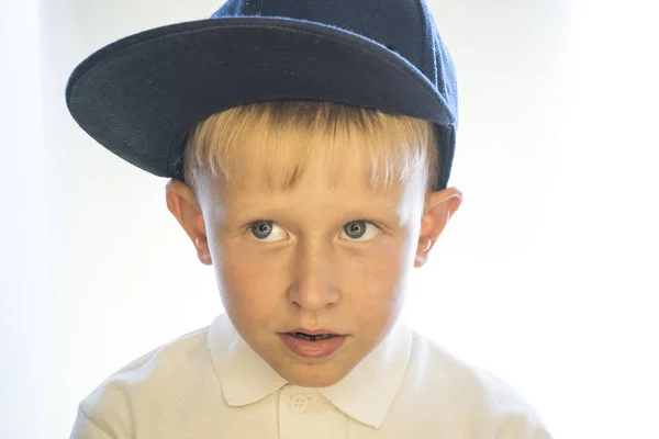 Portrait of a little boy in a cap and a white shirt. — Stock Photo, Image