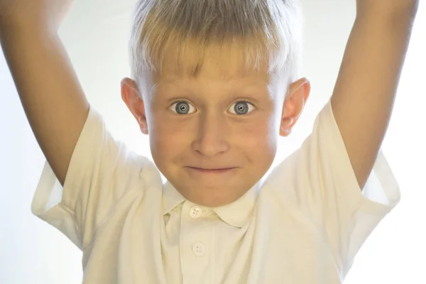 Een kleine jongen met opgeheven armen. — Stockfoto