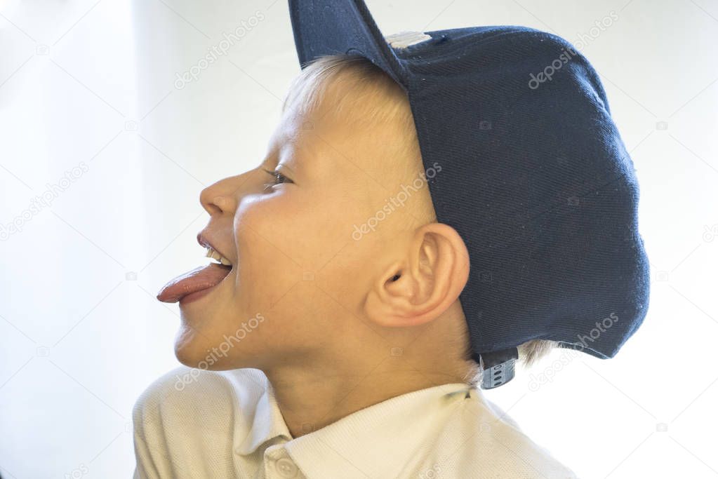 The boy shows the tongue. 