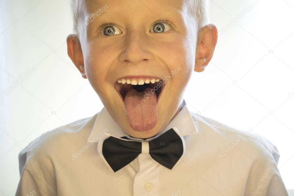 A little boy is showing his tongue