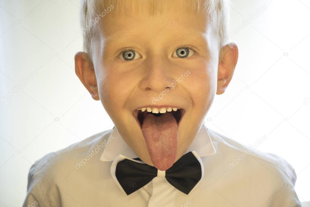A little boy is showing his tongue
