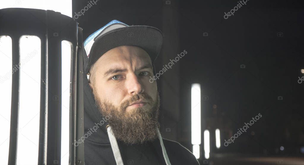 Portrait of a bearded guy with a lamp. A bearded guy on the stre