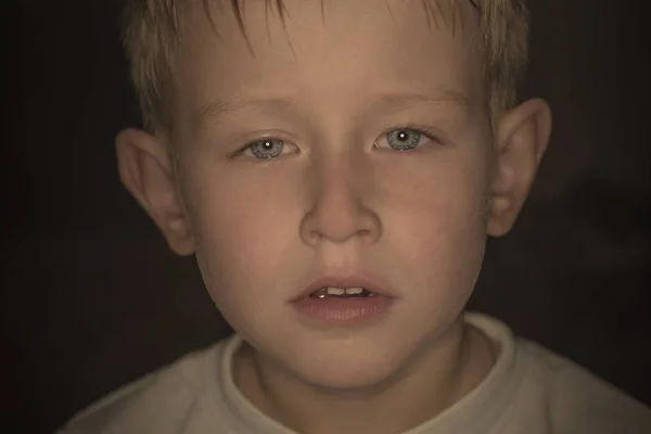 Portrait of a sad boy in the dark. Portrait of a little boy. Han — Stock Photo, Image