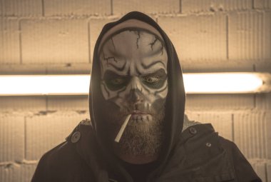 Bir sigara ile kafatası. Bir sakallı bir makyaj ile kel bir adam sk