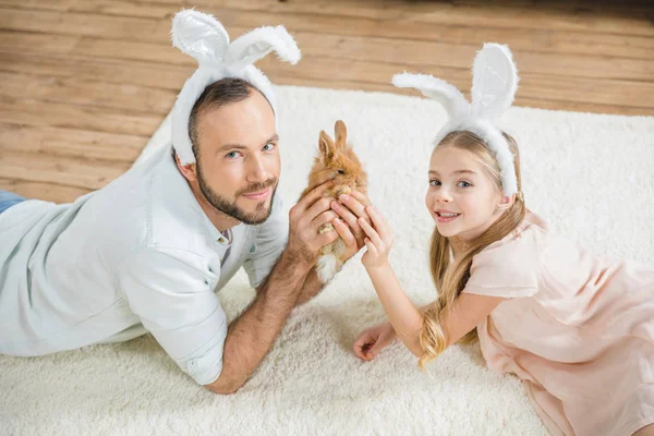 Padre e figlia giocano con il coniglio — Foto Stock