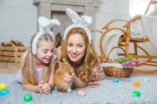 Mother and daughter playing with rabbit — Stock Photo, Image