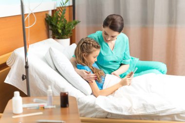 Doctor and girl with digital tablet  clipart