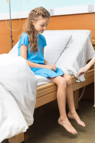 Little patient sitting on bed — Free Stock Photo