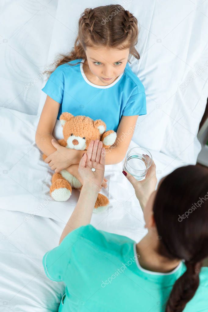 Doctor giving pill to patient 