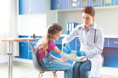 Doktor ve kız yaralı el ile