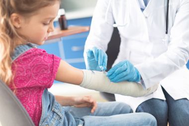 Doktor ve kız yaralı el ile