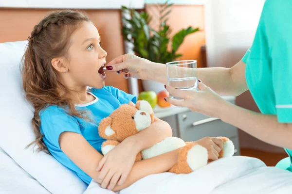 Médico dando píldora al paciente — Foto de Stock