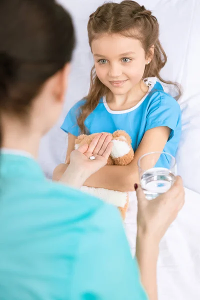 Médico dando píldora al paciente — Foto de Stock