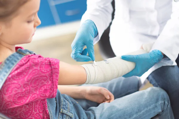 Doctor and girl with injured hand — Stock Photo, Image
