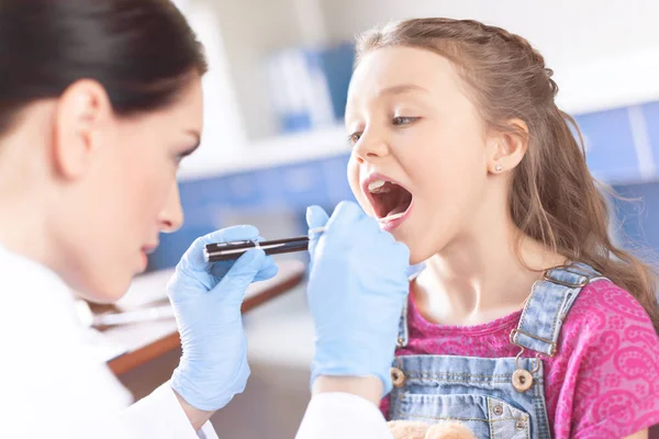 Médico chequeando garganta de chica — Foto de Stock