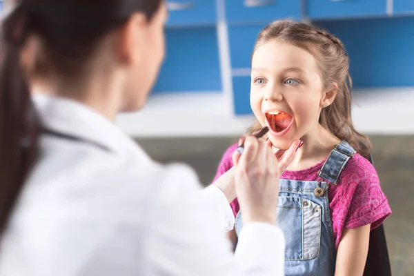 Doctor checking throat of girl — Stock Photo, Image