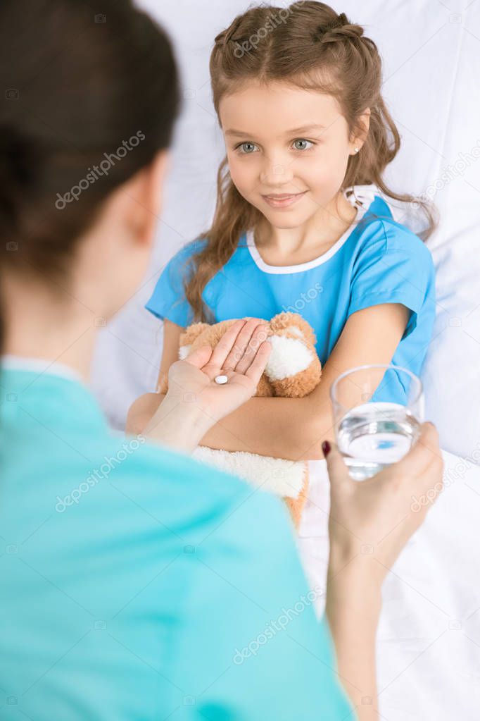 Doctor giving pill to patient 