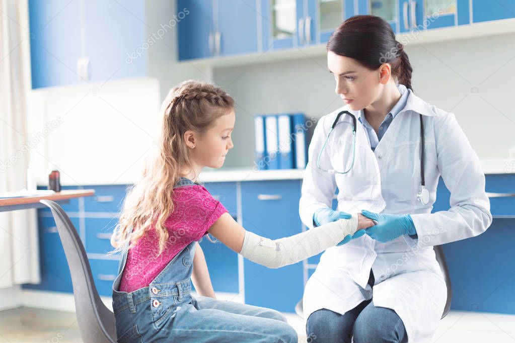 Doctor and girl with injured hand