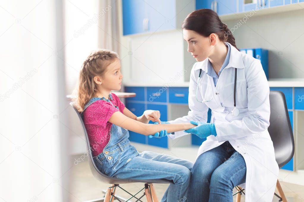 Doctor and girl with injured hand