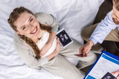 Doctor and woman with ultrasound scans  clipart