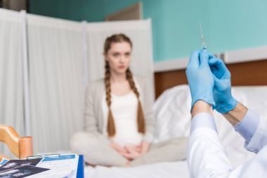 Hamile kadın ve doktor şırınga ile 