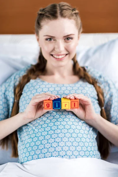 Pregnant woman with word girl — Free Stock Photo