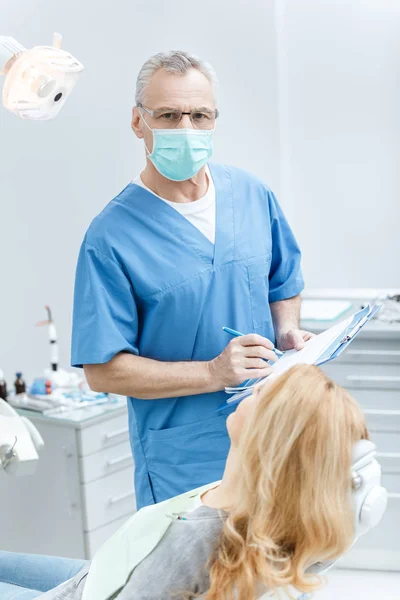 Dentista con paciente en clínica dental — Foto de Stock