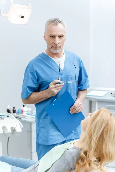 Dentista con paziente in clinica dentistica — Foto Stock