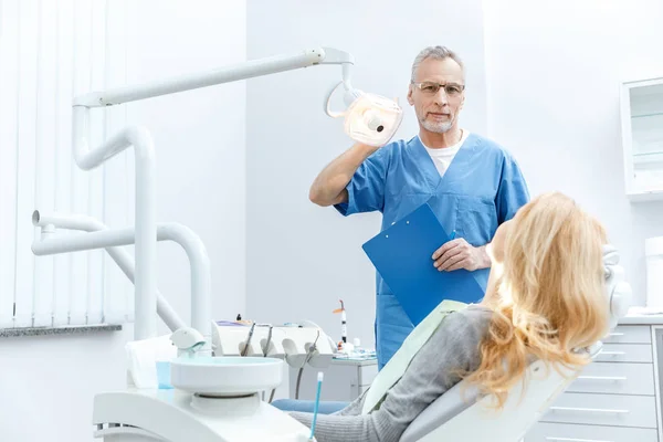 Dentista con paziente in clinica dentistica — Foto Stock