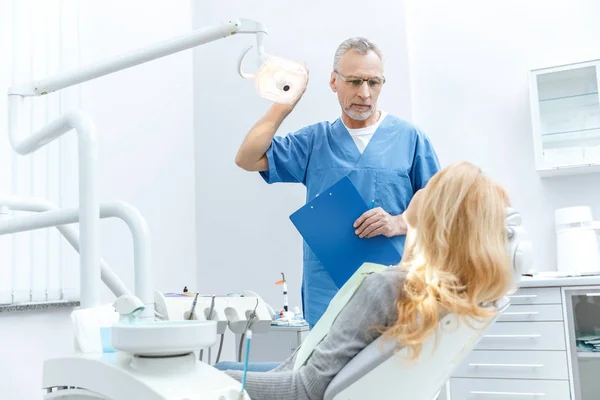 Dentista com paciente em clínica odontológica — Fotografia de Stock